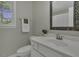 Bathroom vanity featuring a white countertop, framed mirror, window and stainless faucet at 3204 Peachford Ln, Raleigh, NC 27616