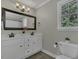 Bathroom with double sink vanity, framed mirror, and natural light from the window at 3204 Peachford Ln, Raleigh, NC 27616