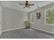Neutral bedroom with a ceiling fan, a rocking chair and a window featuring leafy outdoor views at 3204 Peachford Ln, Raleigh, NC 27616