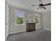 Neutral bedroom with a ceiling fan, two bright windows, and a wooden dresser at 3204 Peachford Ln, Raleigh, NC 27616