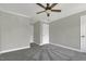 Bedroom features neutral walls, grey carpeting, white trim, and a ceiling fan at 3204 Peachford Ln, Raleigh, NC 27616