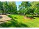 Expansive backyard with a stone patio, lush lawn, mature trees, and a wooden fence, offering privacy and space at 3301 Manor Ridge Dr, Raleigh, NC 27603