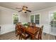 Dining room with wood table that seats six, with a ceiling fan and natural light from large windows at 3301 Manor Ridge Dr, Raleigh, NC 27603
