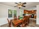 Dining room adjacent to kitchen with a dining table that seats six, illuminated by a ceiling fan at 3301 Manor Ridge Dr, Raleigh, NC 27603