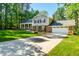 Charming brick and siding home featuring a long drive, an attached garage and a manicured front lawn at 3301 Manor Ridge Dr, Raleigh, NC 27603