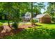 Charming exterior with a mix of brick and siding, surrounded by mature trees and a well-manicured lawn at 3301 Manor Ridge Dr, Raleigh, NC 27603