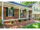 Inviting front porch with brick facade, stylish columns, and hanging plants for an outdoor feel at 3301 Manor Ridge Dr, Raleigh, NC 27603
