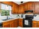 Close up showcasing traditional wood cabinets and black appliances in a cozy kitchen at 3301 Manor Ridge Dr, Raleigh, NC 27603