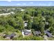 Aerial view of a home surrounded by lush trees and landscaping under a blue sky at 3704 Swann St, Raleigh, NC 27612
