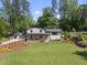 Charming two-story home boasts a bright yellow front door, stone facade, and lush green lawn at 3704 Swann St, Raleigh, NC 27612
