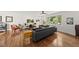 Bright living room features hardwood floors, a ceiling fan, and a large window with backyard views at 3704 Swann St, Raleigh, NC 27612