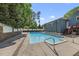 An in-ground pool with concrete decking surrounded by privacy fencing and mature trees at 3704 Swann St, Raleigh, NC 27612