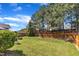 Green backyard with wooden fence, mature trees, and spacious lawn at 3801 Althorp Dr, Raleigh, NC 27616