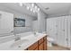 Well-lit bathroom with a double sink vanity, shower and tropical-themed art at 3801 Althorp Dr, Raleigh, NC 27616