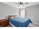 Comfortable bedroom with a ceiling fan, window, and a classic wooden bed frame topped with blue bedding at 3808 Hopper St, Raleigh, NC 27616