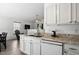 Kitchen with granite countertops, white cabinets, and modern appliances, with a glimpse into the living room at 3808 Hopper St, Raleigh, NC 27616