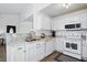 Updated kitchen featuring granite countertops, white cabinetry, stainless steel sink, and modern appliances at 3808 Hopper St, Raleigh, NC 27616