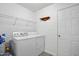 Functional laundry room with a washer, dryer, shelving, and door at 3808 Hopper St, Raleigh, NC 27616