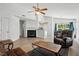 Open-concept living room with fireplace, ceiling fan, and adjacent dining area at 3808 Hopper St, Raleigh, NC 27616