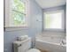 Relaxing bathroom featuring a white tub and a frosted glass window at 404 Cary Pines Dr, Cary, NC 27513