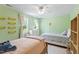 Light green bedroom featuring two beds, bright windows, and unique light fixtures at 404 Cary Pines Dr, Cary, NC 27513