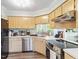 Functional kitchen with stainless steel appliances, light wood cabinets, and a view to the living room at 404 Cary Pines Dr, Cary, NC 27513