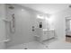 Corner view of the glass walk-in shower with built-in bench, light gray tiled walls and brushed gold fixtures at 411 Flat Rail Trl, Cary, NC 27511
