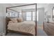 Bedroom with a four poster bed, light wood floors, and plantation shutters at 411 Flat Rail Trl, Cary, NC 27511
