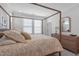 Bedroom with a four poster bed, light wood floors, and plantation shutters at 411 Flat Rail Trl, Cary, NC 27511