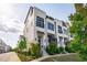 Stylish townhomes with white brick, black accents, manicured landscaping, and inviting front entrances at 411 Flat Rail Trl, Cary, NC 27511