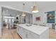 Bright kitchen with quartz island and stainless steel appliances overlooking the dining and living areas at 411 Flat Rail Trl, Cary, NC 27511