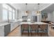 Bright, open kitchen with white cabinetry, an island with seating, and stainless steel appliances at 411 Flat Rail Trl, Cary, NC 27511