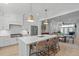 Bright kitchen with quartz island and stainless steel appliances overlooking the dining and living areas at 411 Flat Rail Trl, Cary, NC 27511