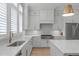 Bright kitchen with white cabinetry, quartz countertops, and stainless steel appliances at 411 Flat Rail Trl, Cary, NC 27511