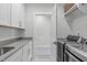 Laundry room with gray countertop space, shaker cabinets, and stainless steel washer and dryer at 411 Flat Rail Trl, Cary, NC 27511