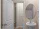 Bathroom featuring a pedestal sink, decorative oval mirror, and neutral wall colors at 412 Ember St, Sanford, NC 27330
