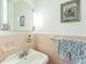 A charming, pink tiled bathroom featuring a pristine sink, complementary fixtures, and tastefully coordinated accessories at 418 S 2Nd St, Smithfield, NC 27577