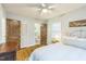 Cozy bedroom with hardwood floors, ceiling fan, white bedding, and adjoining bathroom with decorative, paneled wood door at 418 S 2Nd St, Smithfield, NC 27577