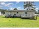 Rear exterior of the home with a deck, sliding glass door and lush green backyard at 43 Columbus Ct, Spring Lake, NC 28390