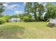 Spacious backyard with lush green grass and mature trees on a sunny day at 43 Columbus Ct, Spring Lake, NC 28390