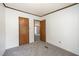 This bedroom features neutral walls and carpet, with doorways to other rooms in the home at 43 Columbus Ct, Spring Lake, NC 28390