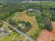 Aerial view of a property featuring a house, fields, pond, and surrounding trees at 4314 Hopkins Rd, Middlesex, NC 27557