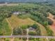 Aerial view of a property featuring a house, grassy lawn, pond, and surrounding trees at 4314 Hopkins Rd, Middlesex, NC 27557