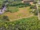 An aerial view showcasing a field and pond, complemented by surrounding trees at 4314 Hopkins Rd, Middlesex, NC 27557