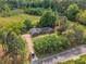 Aerial view capturing the house with surrounding large trees, fields, and a long driveway at 4314 Hopkins Rd, Middlesex, NC 27557
