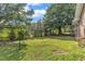 Backyard featuring a grassy lawn, mature trees, and partial fence at 4314 Hopkins Rd, Middlesex, NC 27557