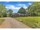 Wide driveway leading up to brick home with verdant front lawn and lush trees at 4314 Hopkins Rd, Middlesex, NC 27557