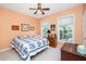 Cozy bedroom with light orange walls, two windows for natural light, and a bed featuring a patterned blue quilt at 437 New Parkside Dr, Chapel Hill, NC 27516