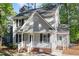 View of the home's exterior showcasing its gray siding, white trim, and well-kept landscaping at 4621 Worthington Ln, Raleigh, NC 27604
