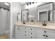 The modern bathroom has double sinks, dual mirrors, white cabinets, and black hardware at 5117 Dove Forest Ln, Apex, NC 27539